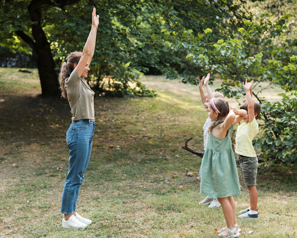 full-shot-teacher-kids-with-hands-up (1).jpg