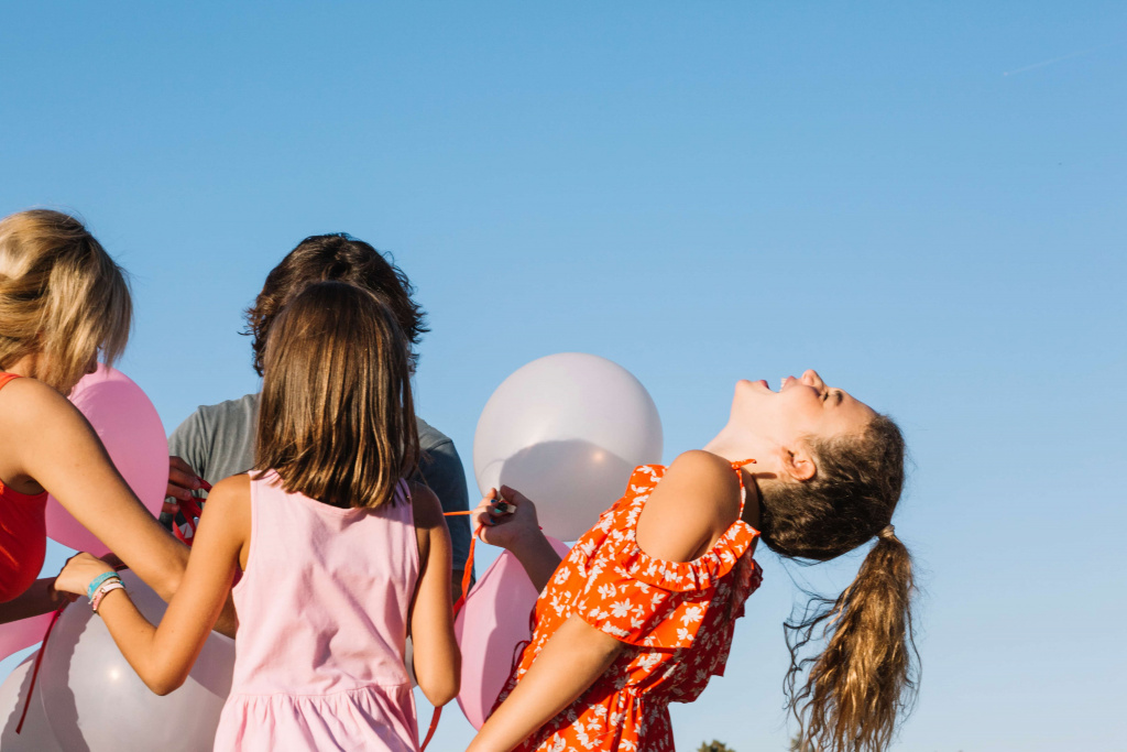 laughing-girl-holding-balloons-with-family (1).jpg